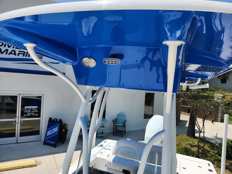 Slide: The Image of 2023 Sea Born FX22 Bay boat with blue T-top at a marina. - 4