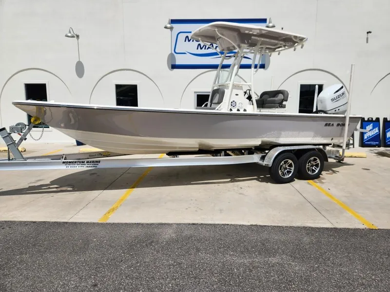 The Image of 2023 Sea Born FX24 Bay boat on a trailer outside a marine dealership. - 0