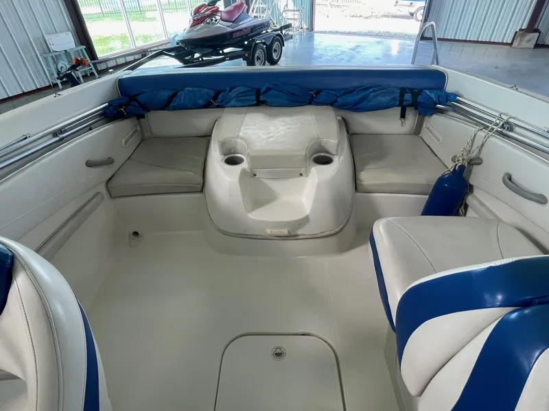 Slide: The Image of 2007 Bayliner 212 boat interior with white and blue seating. - 11