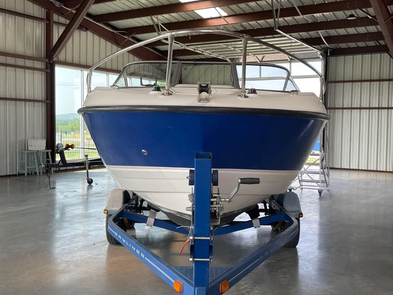 Slide: The Image of 2007 Bayliner 212 boat on a trailer in a covered storage area. - 2