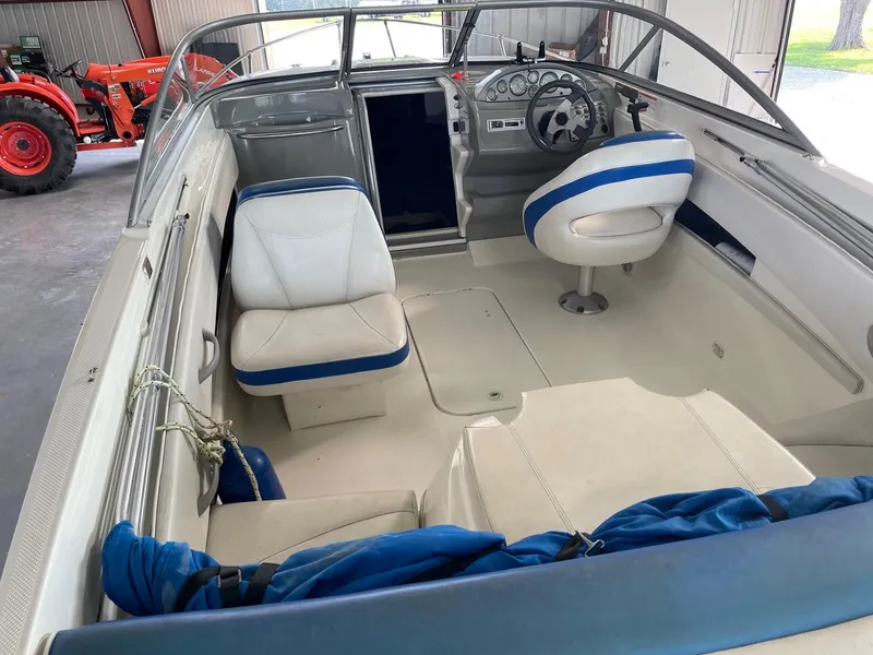 Slide: The Image of 2007 Bayliner 212 boat interior with white and blue seating. - 4