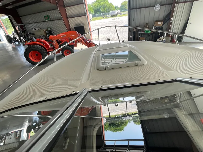 Slide: The Image of 2007 Bayliner 212 boat in a garage with a red tractor in the background. - 8