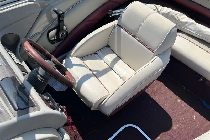 Slide: The Image of 1996 Maxum 1900 SR2 boat interior with beige captain's chair and maroon accents. - 11
