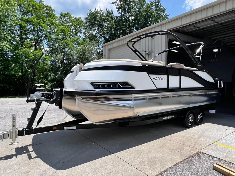 Slide: The Image of 2024 Harris Grand Mariner 230 pontoon boat on trailer outside storage facility. - 13