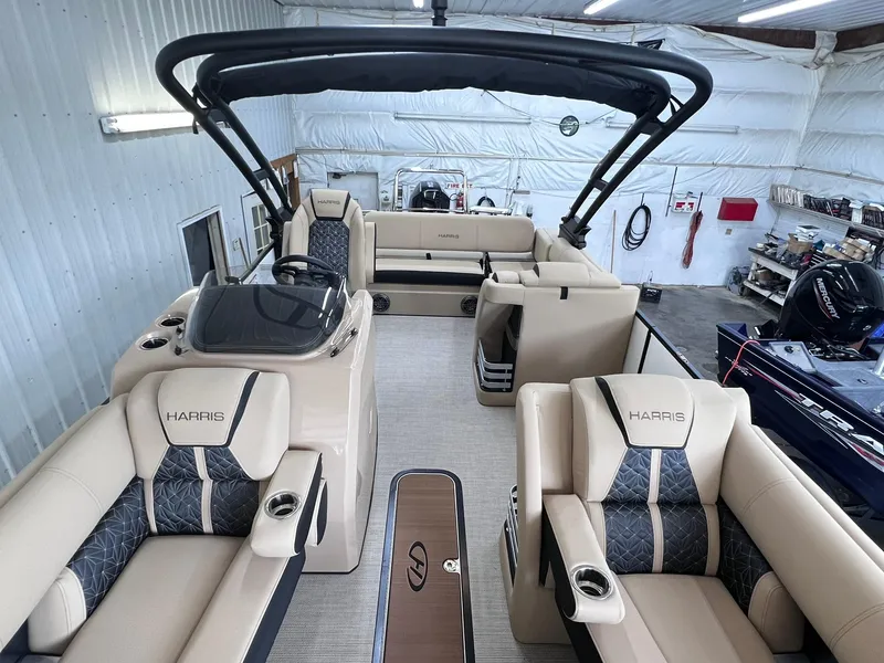 Slide: The Image of 2024 Harris Grand Mariner 230 pontoon boat with luxurious seating in a spacious indoor setting. - 17