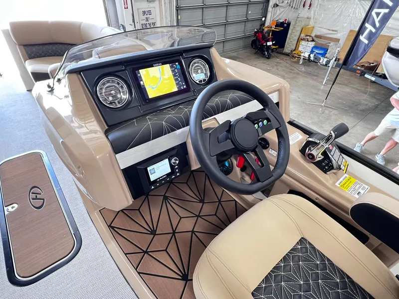 Slide: The Image of 2024 Harris Grand Mariner 230 boat dashboard with steering wheel and navigation system. - 22