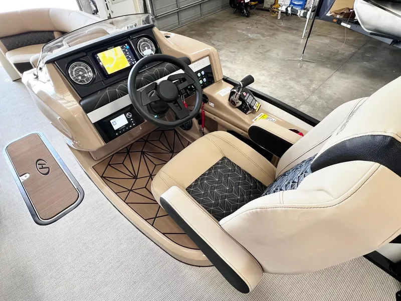 Slide: The Image of 2024 Harris Grand Mariner 230 boat cockpit with steering wheel and control panel. - 23
