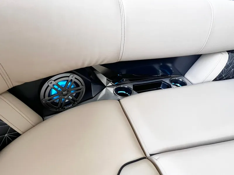 Slide: The Image of 2024 Harris Grand Mariner 230 boat interior with beige seating and blue LED speaker. - 26