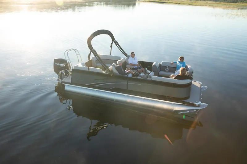 Slide: The Image of 2023 Qwest 820 RLS L pontoon boat on a calm lake with people relaxing. - 17