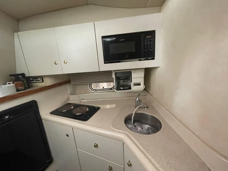 Slide: The Image of 1997 Cruisers Yachts 3375 Esprit kitchen with microwave, stove, sink, and cabinets. - 10