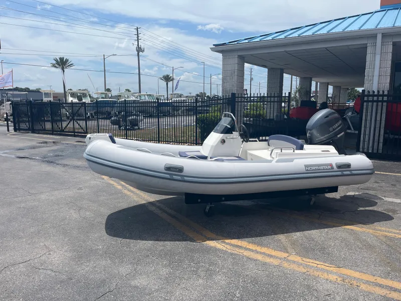 The Image of 2022 Northstar Axis 4.2 inflatable boat displayed outdoors near a building. - 1