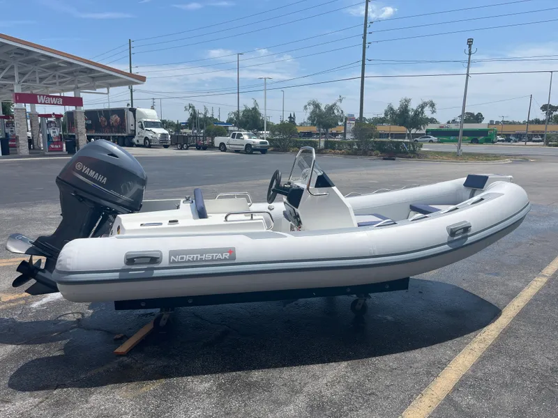 Slide: The Image of 2022 Northstar Axis 4.2 inflatable boat with Yamaha motor at a gas station. - 4