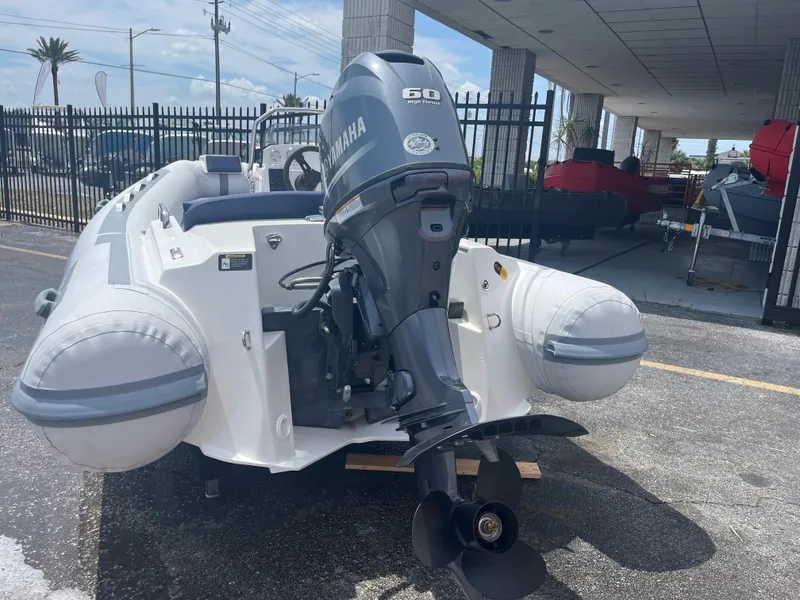 Slide: The Image of 2022 Northstar Axis 4.2 inflatable boat with Yamaha 60 outboard motor, parked outdoors. - 5