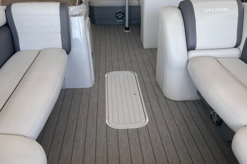 Slide: The Image of 2023 Sylvan Mirage X X5 CLZ interior with gray flooring and white cushioned seats. - 4