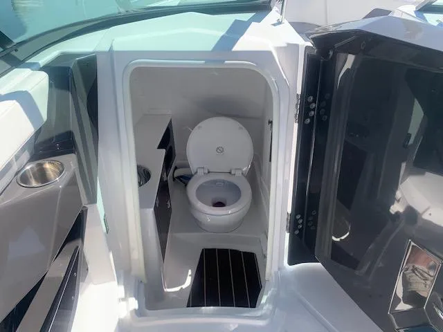 Slide: The Image of 2017 Monterey 258 SS boat interior with a compact marine toilet. - 2