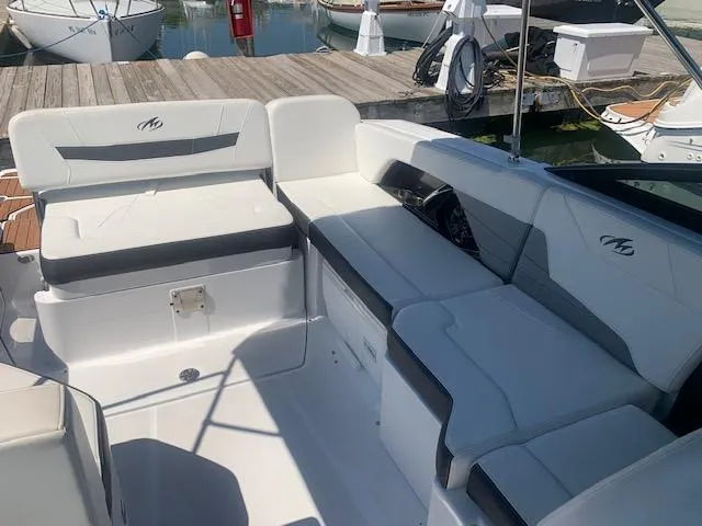 Slide: The Image of 2017 Monterey 258 SS boat interior with white and gray seating at marina. - 7