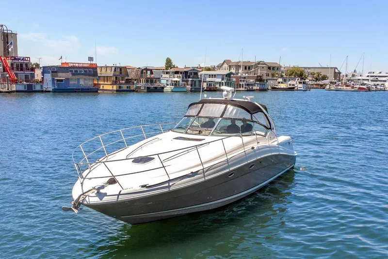 Slide: The Image of 2005 Sea Ray 390 Sundancer yacht docked in a marina with waterfront buildings. - 10