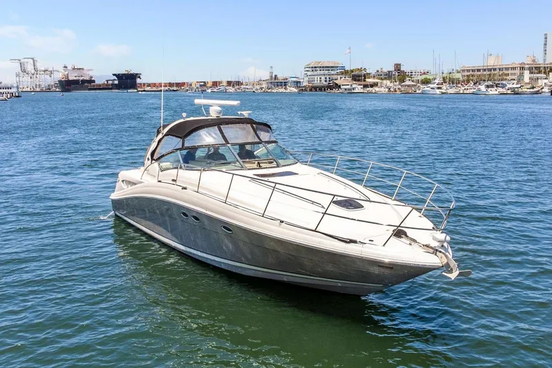 Slide: The Image of 2005 Sea Ray 390 Sundancer yacht on calm waters near a marina. - 11