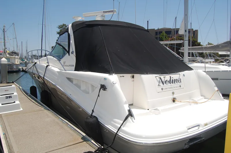 Slide: The Image of 2005 Sea Ray 390 Sundancer docked at marina, rear view with black cover. - 16