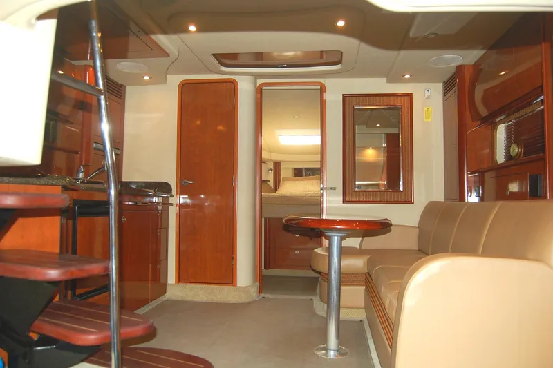 Slide: The Image of Interior of 2005 Sea Ray 390 Sundancer yacht with elegant wood finishes and cozy seating area. - 24
