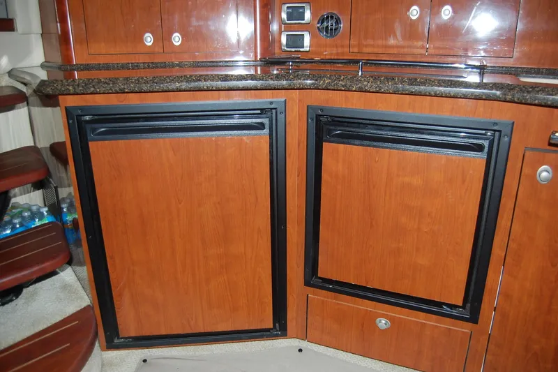 Slide: The Image of 2005 Sea Ray 390 Sundancer interior with wood cabinetry and built-in appliances. - 38