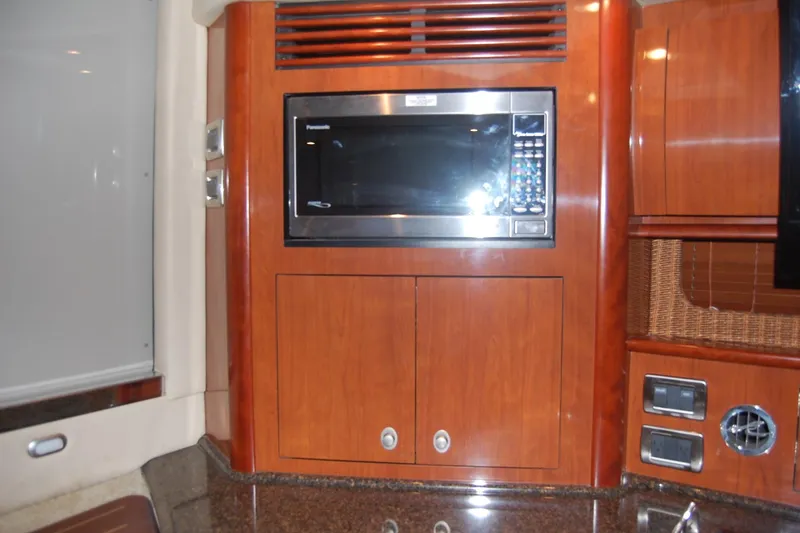 Slide: The Image of 2005 Sea Ray 390 Sundancer interior with microwave and wooden cabinetry. - 39