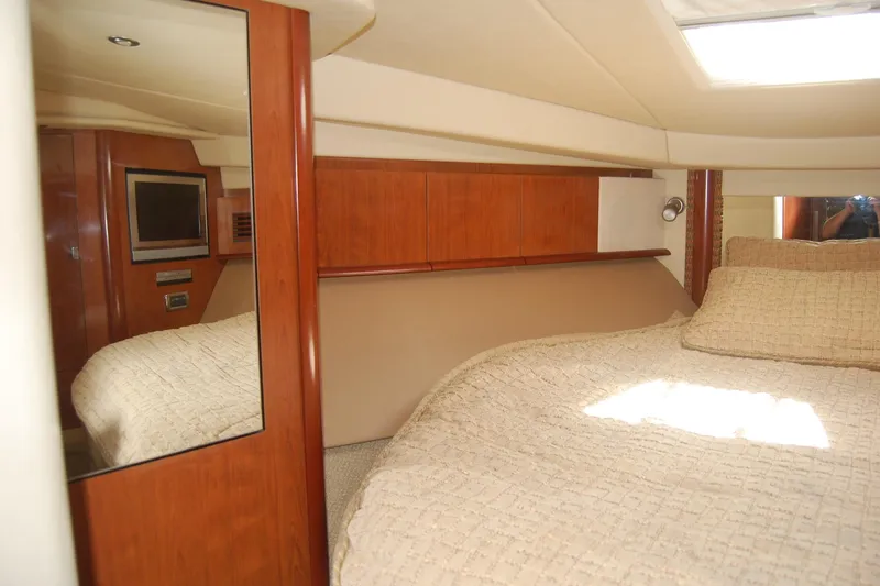 Slide: The Image of Interior cabin of 2005 Sea Ray 390 Sundancer with bed and wooden cabinetry. - 42
