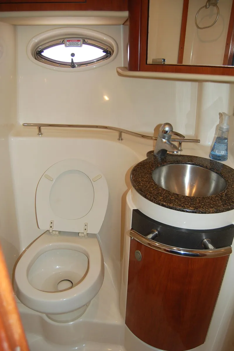 Slide: The Image of 2005 Sea Ray 390 Sundancer bathroom with toilet, sink, and porthole window. - 46