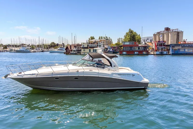 Slide: The Image of 2005 Sea Ray 390 Sundancer yacht cruising in a marina with clear blue skies. - 7