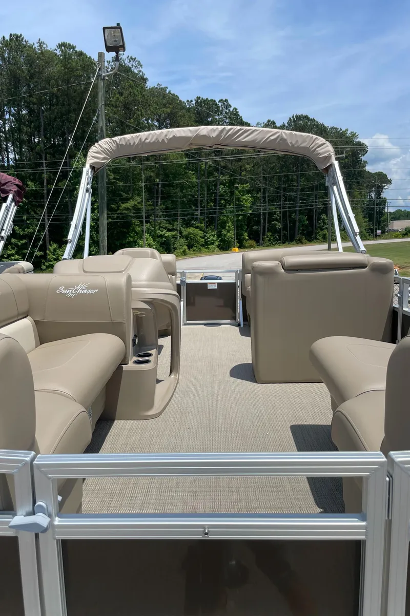 Slide: The Image of 2023 SunChaser Vista 18 LR pontoon boat with beige seating and canopy. - 2