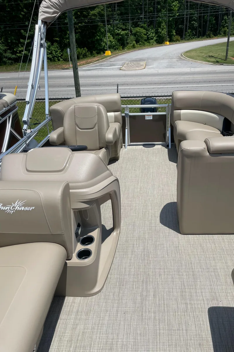 Slide: The Image of 2023 SunChaser Vista 18 LR pontoon boat interior with beige seating and cup holders. - 5