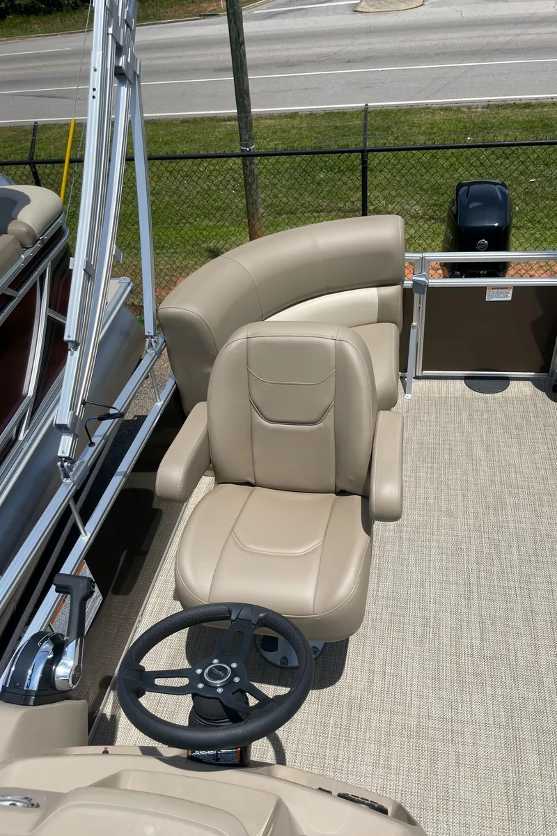 Slide: The Image of 2023 SunChaser Vista 18 LR boat interior with beige captain's chair and steering wheel. - 7
