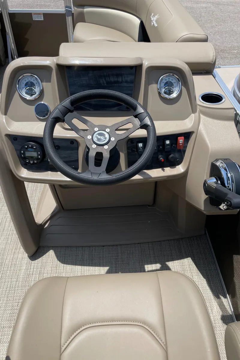 Slide: The Image of 2023 SunChaser Vista 18 LR boat dashboard with steering wheel and controls. - 8