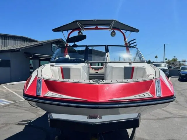 Slide: The Image of 2016 Nautique G21 boat with red and white exterior, parked outdoors. - 3