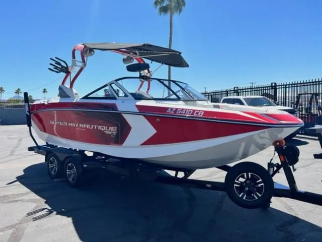 Slide: The Image of 2016 Nautique G21 boat in red and white, parked on a trailer. - 4