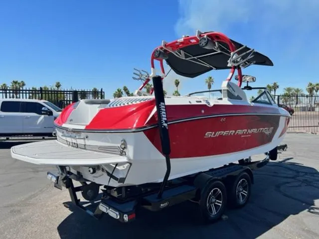 Slide: The Image of 2016 Nautique G21 boat in red and white, parked on a trailer. - 6