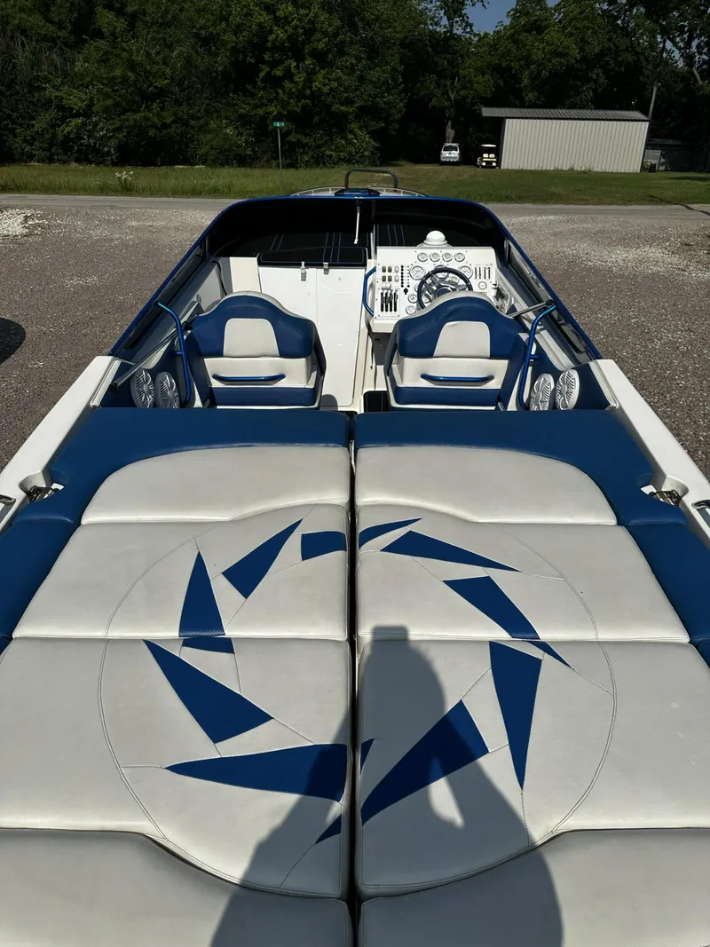 Slide: The Image of 2002 Fountain 42 Lightning speedboat with blue and white interior, docked on gravel. - 7