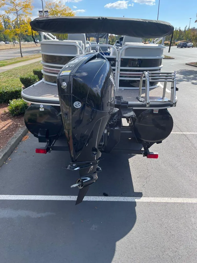 Slide: The Image of 2023 Ranger Reata 243C pontoon boat with outboard motor in parking lot. - 41
