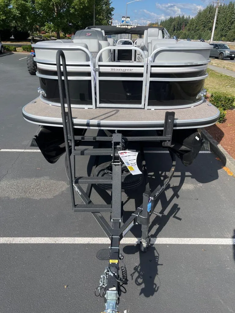Slide: The Image of 2023 Ranger Reata 243C pontoon boat on a trailer in a parking lot. - 42