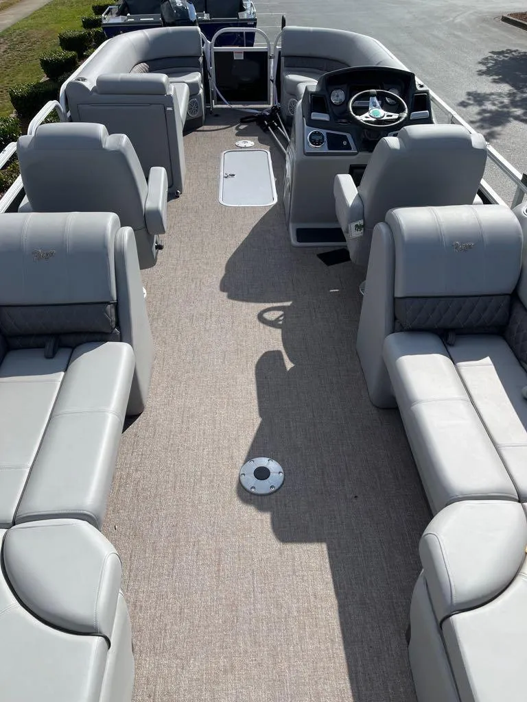 Slide: The Image of 2023 Ranger Reata 243C pontoon boat interior with plush seating and modern dashboard. - 43