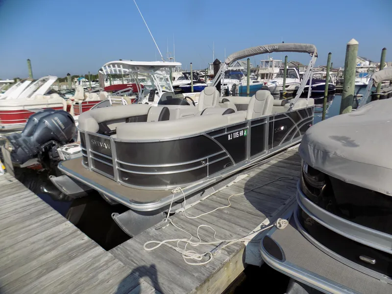 Slide: The Image of 2021 Sylvan Mirage 8522 LZ pontoon boat docked at a marina. - 1