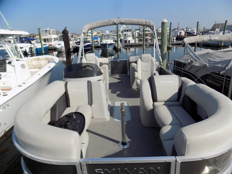 Slide: The Image of 2021 Sylvan Mirage 8522 LZ pontoon boat docked at a marina, featuring spacious seating. - 3