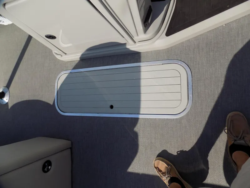 Slide: The Image of 2021 Sylvan Mirage 8522 LZ boat deck with storage compartment and shadowed flooring. - 6