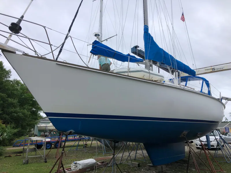 Slide: The Image of 1984 Morgan 454 sailboat with blue sails on stands. - 11