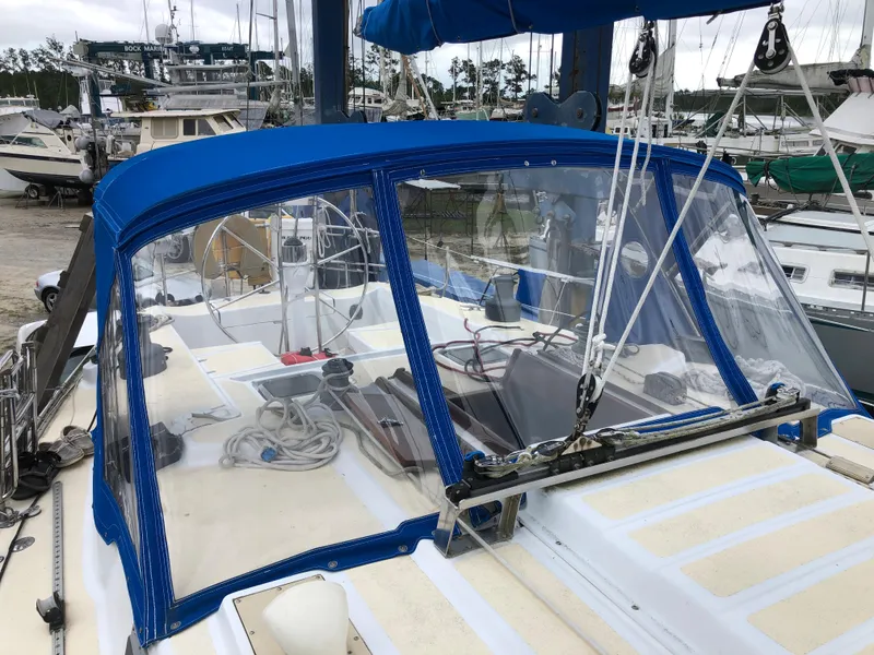 Slide: The Image of 1984 Morgan 454 sailboat with blue cover in harbor. - 19