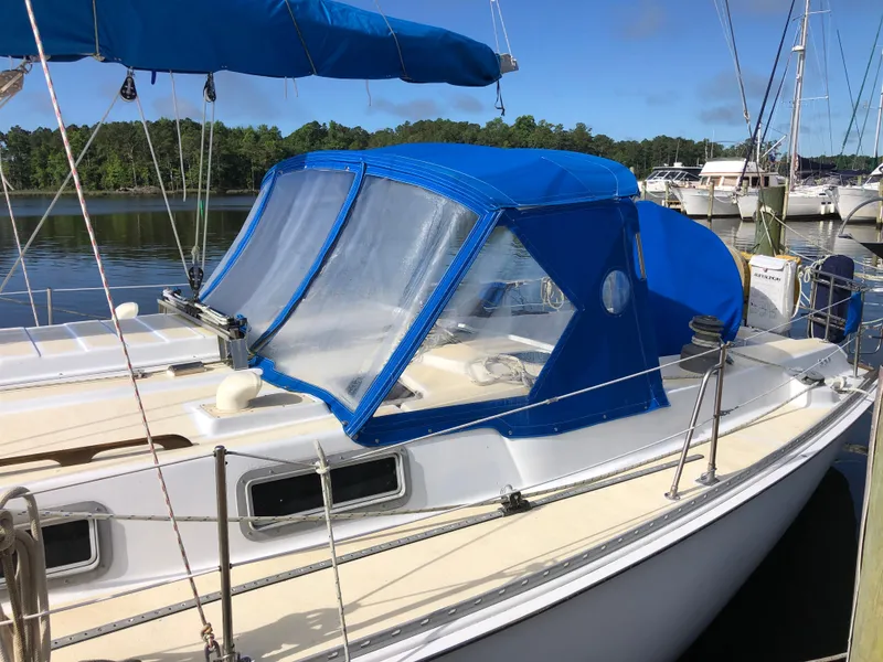 Slide: The Image of 1984 Morgan 454 sailboat with blue cover docked at marina. - 2