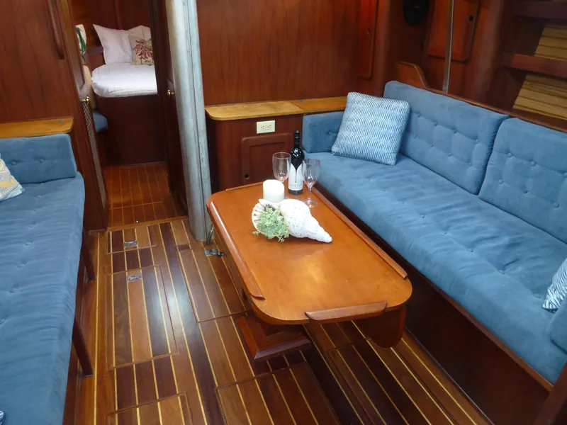 Slide: The Image of Interior of a 1984 Morgan 454 yacht with wooden flooring and blue upholstery. - 23