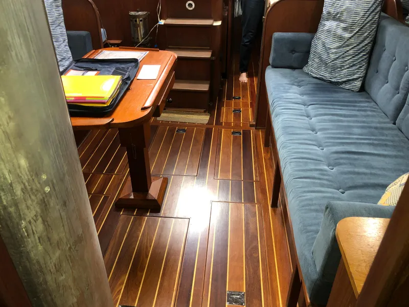 Slide: The Image of Interior of a 1984 Morgan 454 yacht with wooden flooring and blue upholstery. - 24
