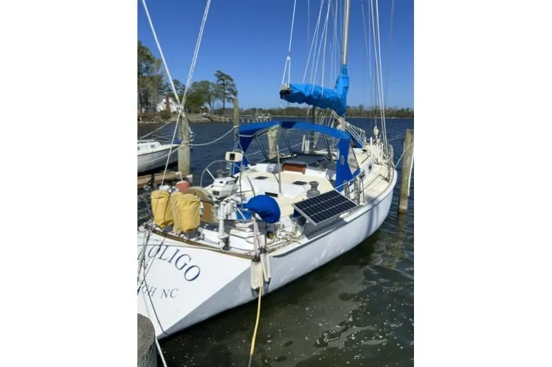 Slide: The Image of 1984 Morgan 454 sailboat docked, featuring blue sail cover and solar panel. - 41