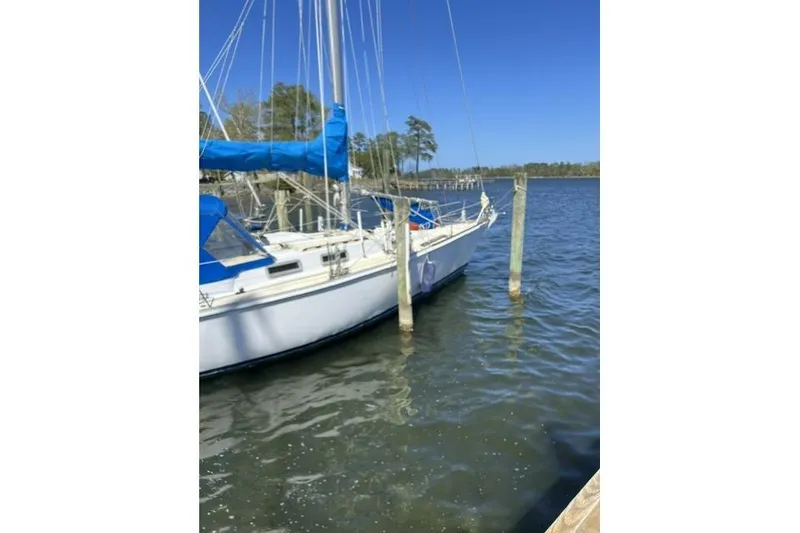 Slide: The Image of 1984 Morgan 454 sailboat docked on a sunny day with blue sails. - 42